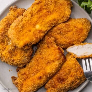 a grey plate full of oven fried chicken.